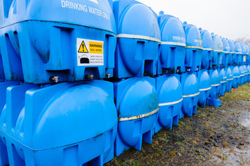 Blue drinking water storage tanks (bowsers) in storage awaiting deployment in an emergency water...