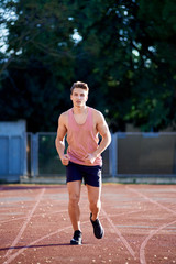 Obraz premium Young muscular man running on the track