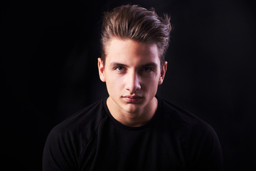 Fashion portrait of elegant young handsome man isolated on black background