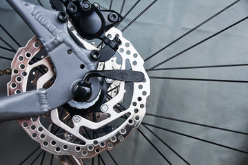 Rear wheel disc brake rotor of the grey sport bike close up on the grey background