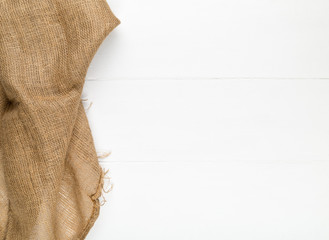 Burlap fabric cloth on white wooden kitchen table with copyspace