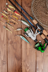 Fishing tackle - fishing spinning, hooks and lures on wooden background with copy space