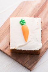 Carrot cake slice with frosting carrot topper
