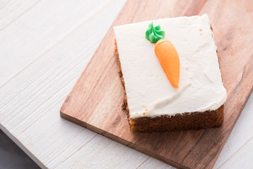 Carrot cake slice with frosting carrot topper