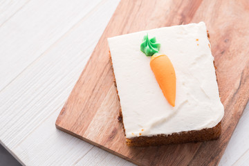 Carrot cake slice with frosting carrot topper
