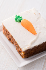 Carrot cake slice with frosting carrot topper