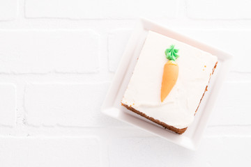 Carrot cake slice with frosting carrot topper