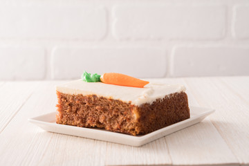 Carrot cake slice with frosting carrot topper