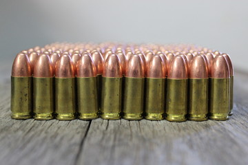 9mm bullets lined up on barn wood