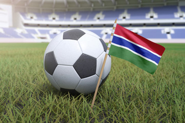 Naklejka premium Gambian flag in stadium field with soccer football