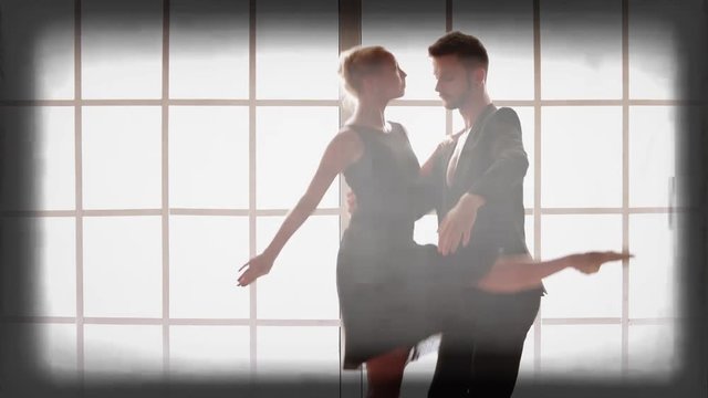 Young beautiful couple dancing in studio. Flexible ballet couple practicing at contemporary dance studio.