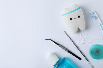 Composition with tooth and dentist tools on white background, top view. Space for text