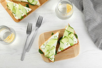 Flat lay composition with traditional English cucumber sandwiches on white wooden background