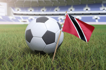 Naklejka premium Trinidad and Tobago flag in stadium field with soccer football