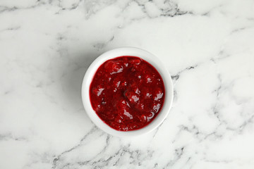 Bowl of cranberry sauce on marble background, top view © New Africa