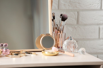 Different makeup products and accessories on dressing table