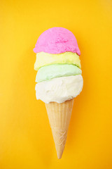 Ice-cream scoops variety in waffle ice cream cone on bright sunny background. Summer, heat, vacation, refreshment, traditional seasonal cold sweets