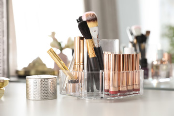 Luxury makeup products and accessories on dressing table with mirror, closeup