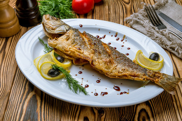 Fried sea bass on white plate