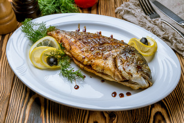 Dorado on grill on white plate