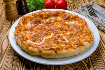 khachapuri with cheese on white plate