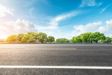 Country road and green forest natural landscape under the blue sky