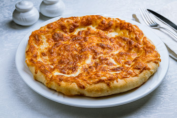 khachapuri with cheese on white plate