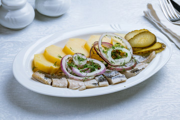 Herring with potatoes on white plate