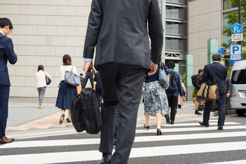 横断歩道を渡るビジネスマンの後ろ姿