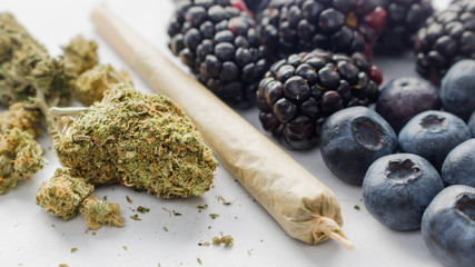 Marijuana Buds, A Rolled Joint & Organic Blackberries & Blueberries On White