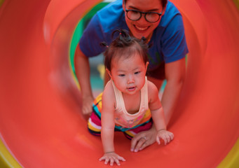 Fototapeta na wymiar Asian baby girl playing with mom on playground