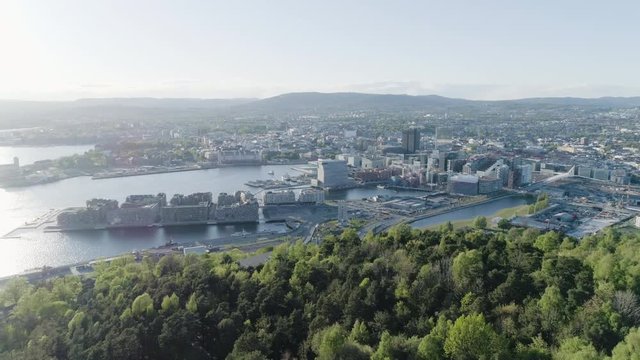 4K aerial of the Oslo city line with a backdrop of downtown Oslo and Bjoervika, a popular tourist attraction with the Munch museum, Barcode and Soerenga pier, in evening with forward motion.