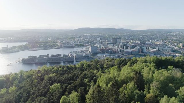 4K aerial of the Oslo city line with a backdrop of downtown Oslo and Bjoervika, a popular tourist attraction with the Munch museum, Barcode and Soerenga pier, in evening with forward motion.