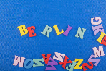 BERLIN word on blue background composed from colorful abc alphabet block wooden letters, copy space for ad text. Learning english concept.