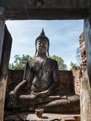 Ancient Buddha statue in ruined temple in Thailand
