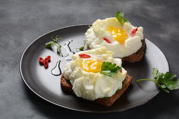 Delicate baked egg. Orsini eggs in the cloud. French breakfast.Cloud egg on toast 