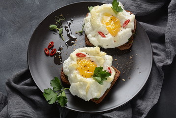 Delicate baked egg. Orsini eggs in the cloud. French breakfast.Cloud egg on toast 