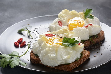 Delicate baked egg. Orsini eggs in the cloud. French breakfast.Cloud egg on toast 