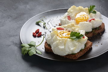 Delicate baked egg. Orsini eggs in the cloud. French breakfast.Cloud egg on toast 