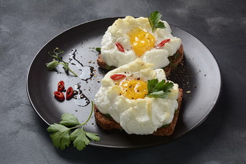 Delicate baked egg. Orsini eggs in the cloud. French breakfast.Cloud egg on toast 