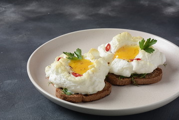 Delicate baked egg. Orsini eggs in the cloud. French breakfast.Cloud egg on toast 