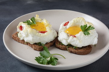 Delicate baked egg. Orsini eggs in the cloud. French breakfast.Cloud egg on toast 