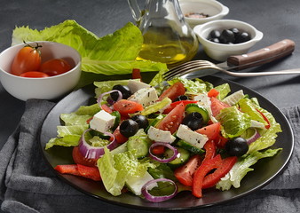 Greek salad with fresh cucumber, cherry tomatoes, sweet pepper, lettuce,red onion, olives and olive oil and feta cheese. Healthy food concept