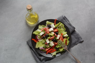 Greek salad with fresh cucumber, cherry tomatoes, sweet pepper, lettuce,red onion, olives and olive oil and feta cheese. Healthy food concept