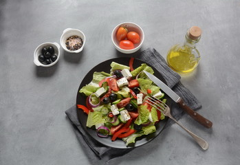 Greek salad with fresh cucumber, cherry tomatoes, sweet pepper, lettuce,red onion, olives and olive oil and feta cheese. Healthy food concept
