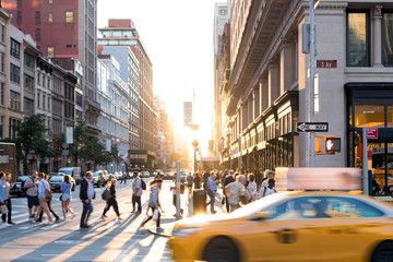 De gele taxicabine van New York City raast voorbij de mensenmassa& 39 s op de kruising van 23rd Street en 5th Avenue in Midtown Manhattan