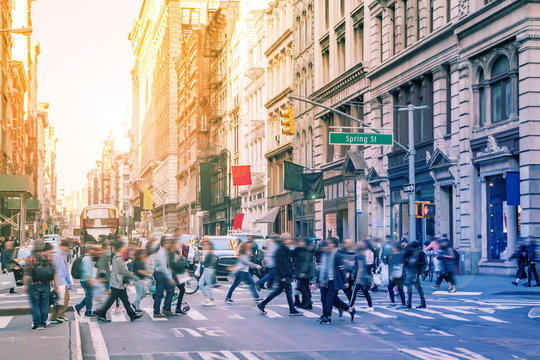 Diverse Groups Of People Walk Across The Crowded Intersection Of Broadway And Spring Street In The SoHo Neighborhood Of Manhattan In New York City