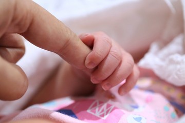 New born baby hold mom's finger