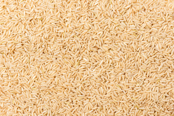 Brown rice background with spoon.