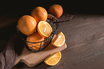 Basket with fresh oranges on wooden table